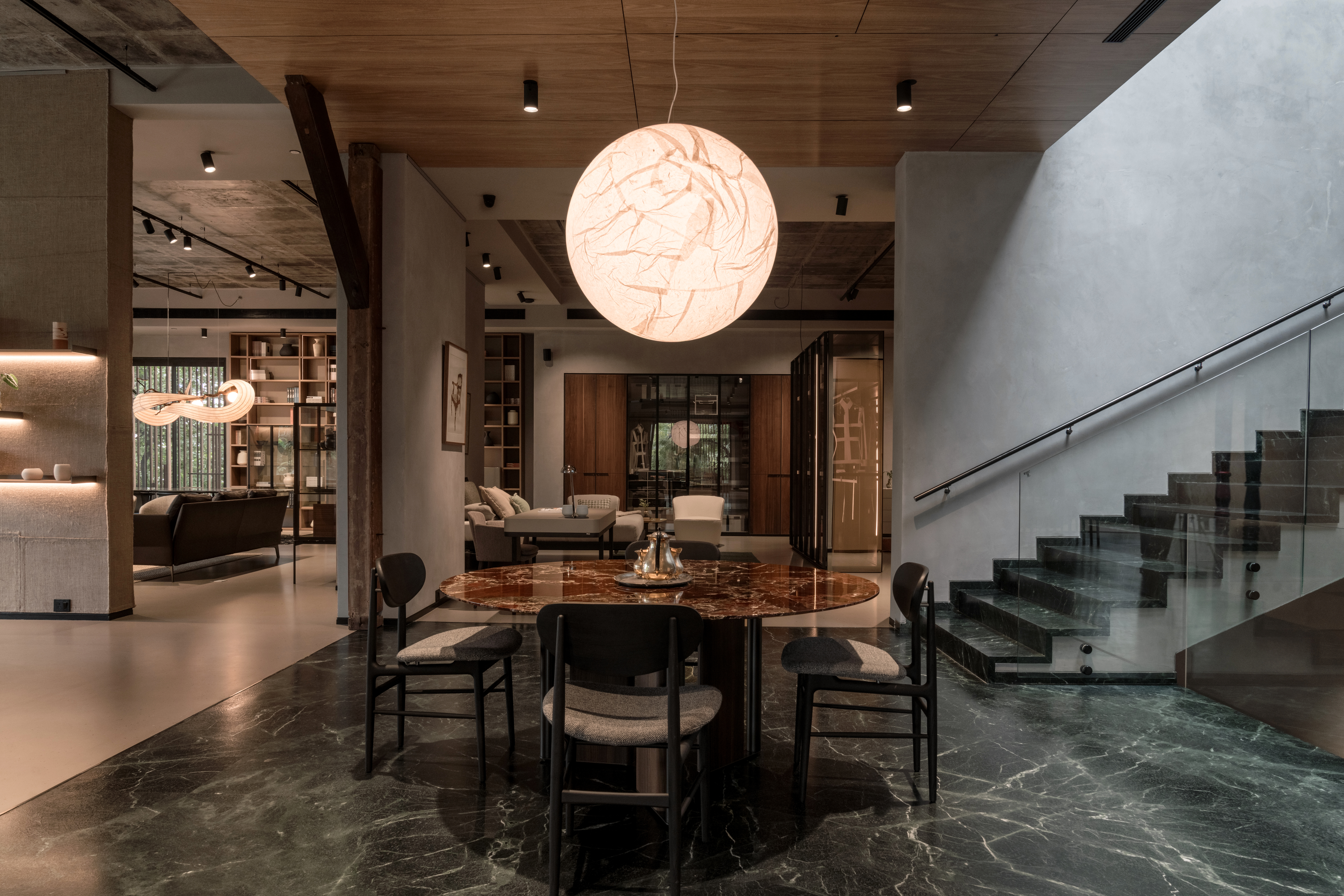 A sculptural sphere pendant suspended over a marble dining table